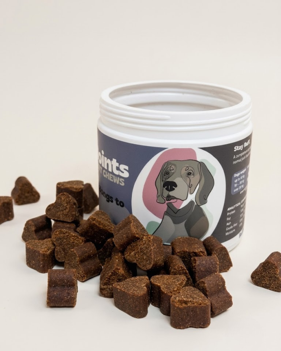 Jar of dog treats with treats spilling out on a white background