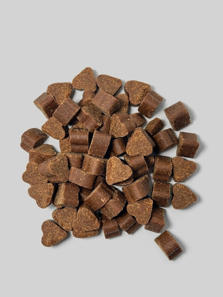 Pet treats spilling out of a tipped-over container labeled 'Jefr' on a white background