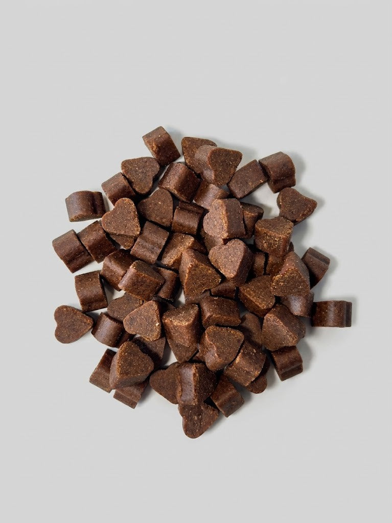 Brown heart-shaped soft chews on a gray background